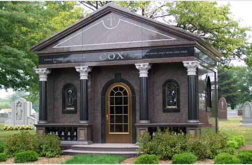 Cox black stone mausoleum with columns, windows, and raised steps
