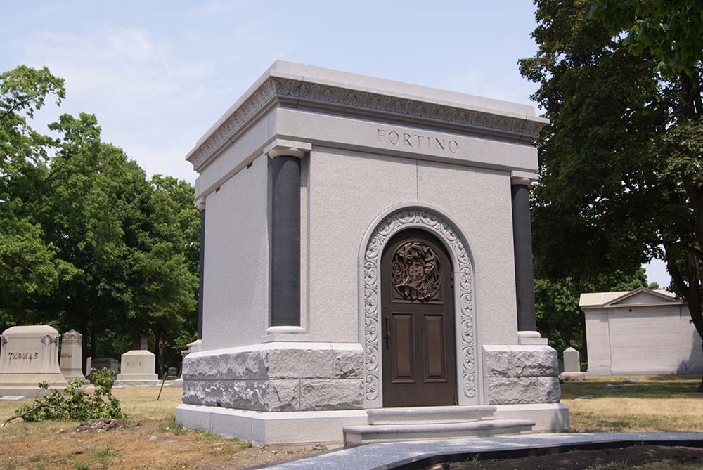 Private mausoleum with custom molding bronze door and granite sidewalk