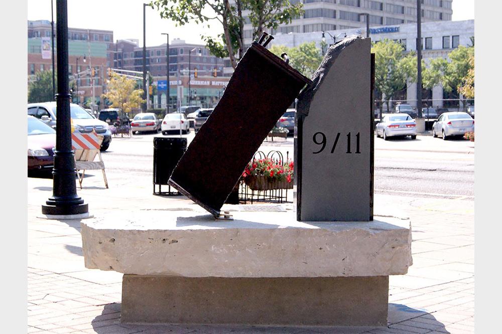 Black 9/11 public memorial on a stone bench