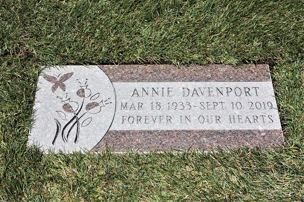 Rose colored granite marker with flowers and butterfly
