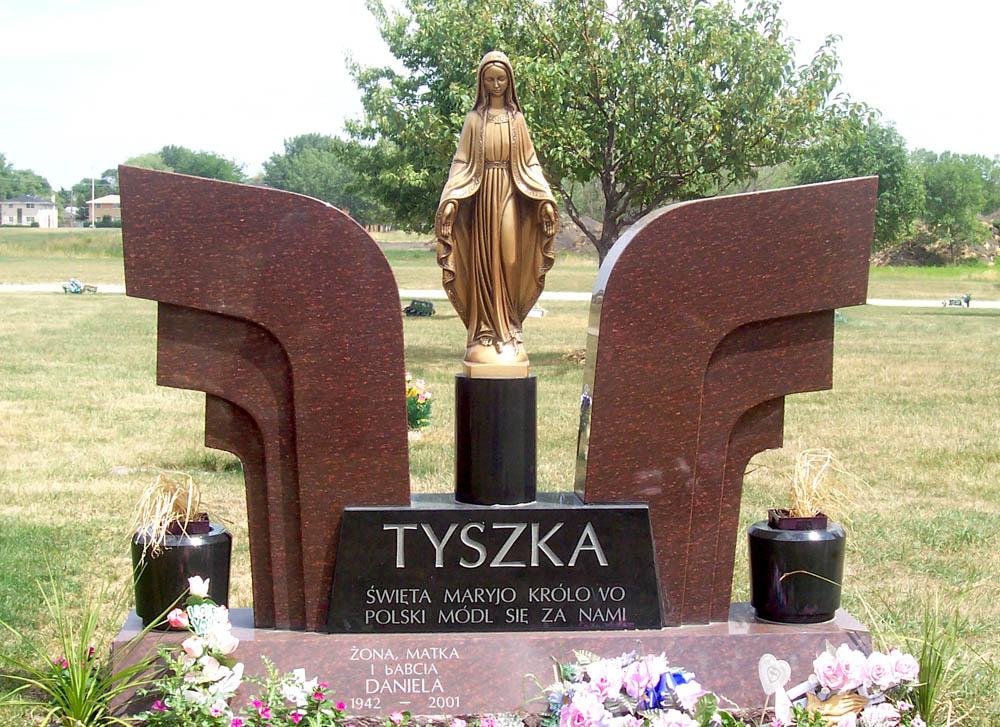 Family monument in brown granite with a bronze statue of Mary