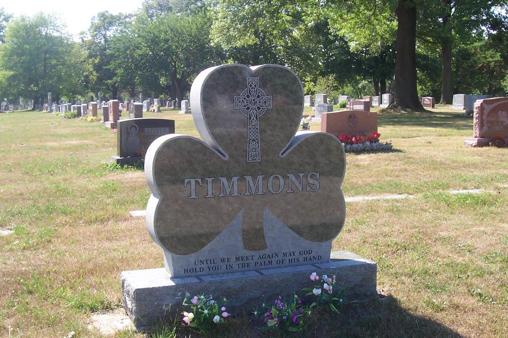 Family monument made with green granite in the shape of a shamrock
