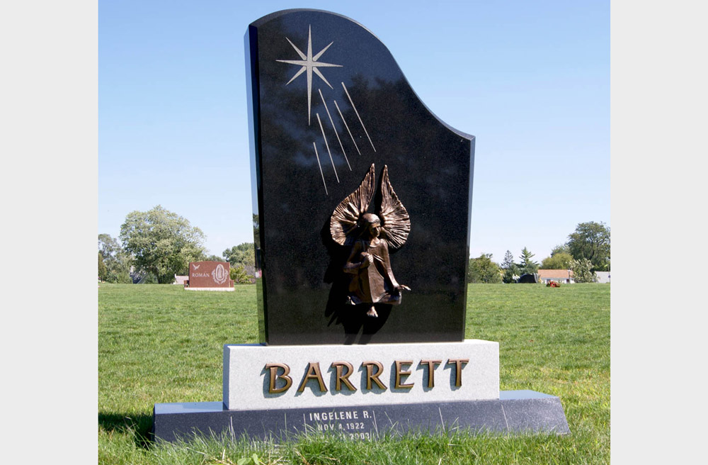 Family monument in multiple granite colors with a bronze angel and bronze letters