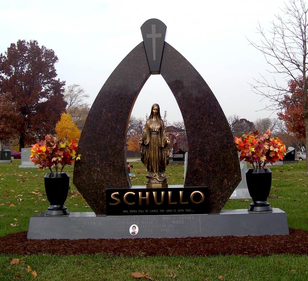 Family monument in multiple granite colors with a bronze statue of Mary and bronze letters