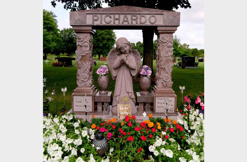 Family monument in pink granite with angel statue and hand-carved roses