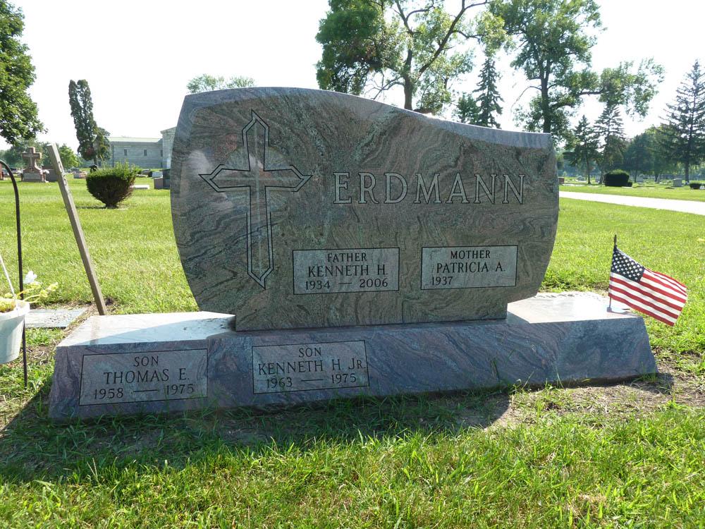 Family monument in variegated granite with a cross carving