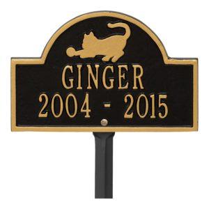 Small black plaque in gold finish with image of cat and dates